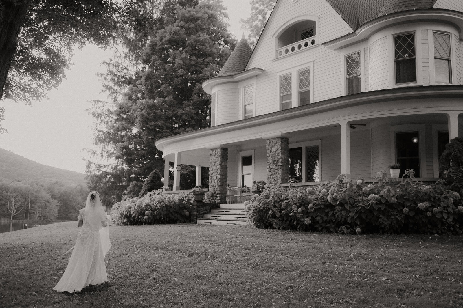 Bride walking toward the house in black and white