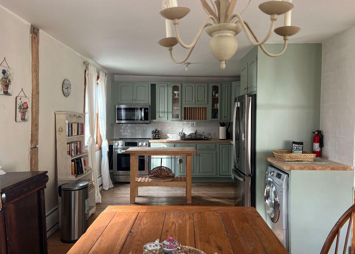 Dining table looking into the kitchen under a chandelier