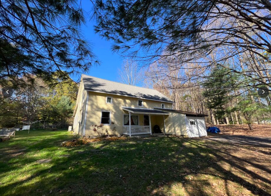 The guest cottage, a yellow farmhouse with a covered porch