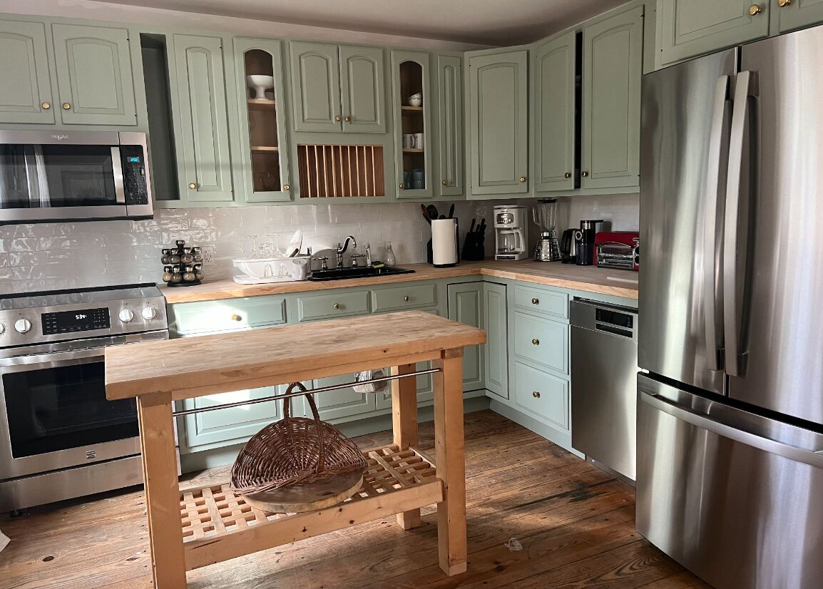 Cottage kitchen with wood island and stainless appliances