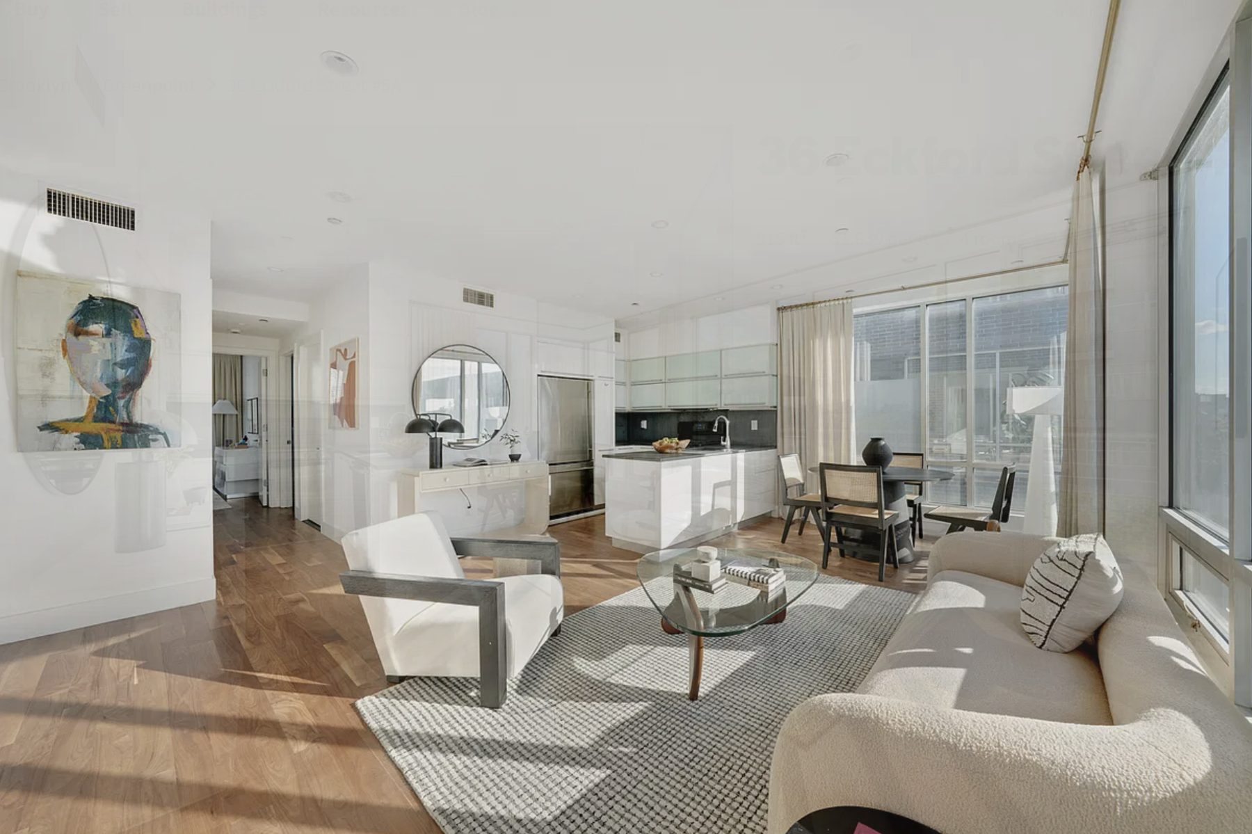 Bright open living and dining room with floor-to-ceiling windows and hardwood floors