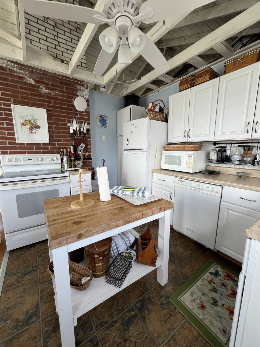 Cottage kitchen with exposed brick and a butcher-block island