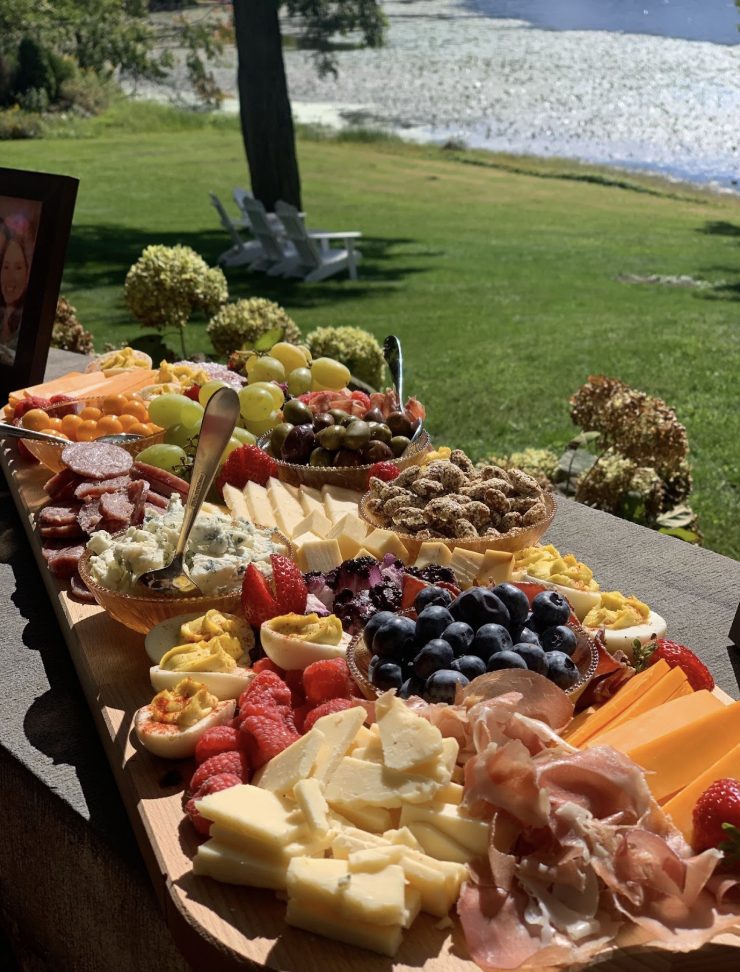 A grazing board on the porch rail overlooking the lake