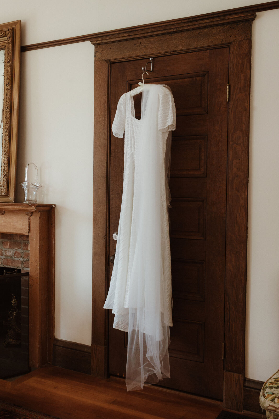 A wedding dress hanging on an antique wooden door