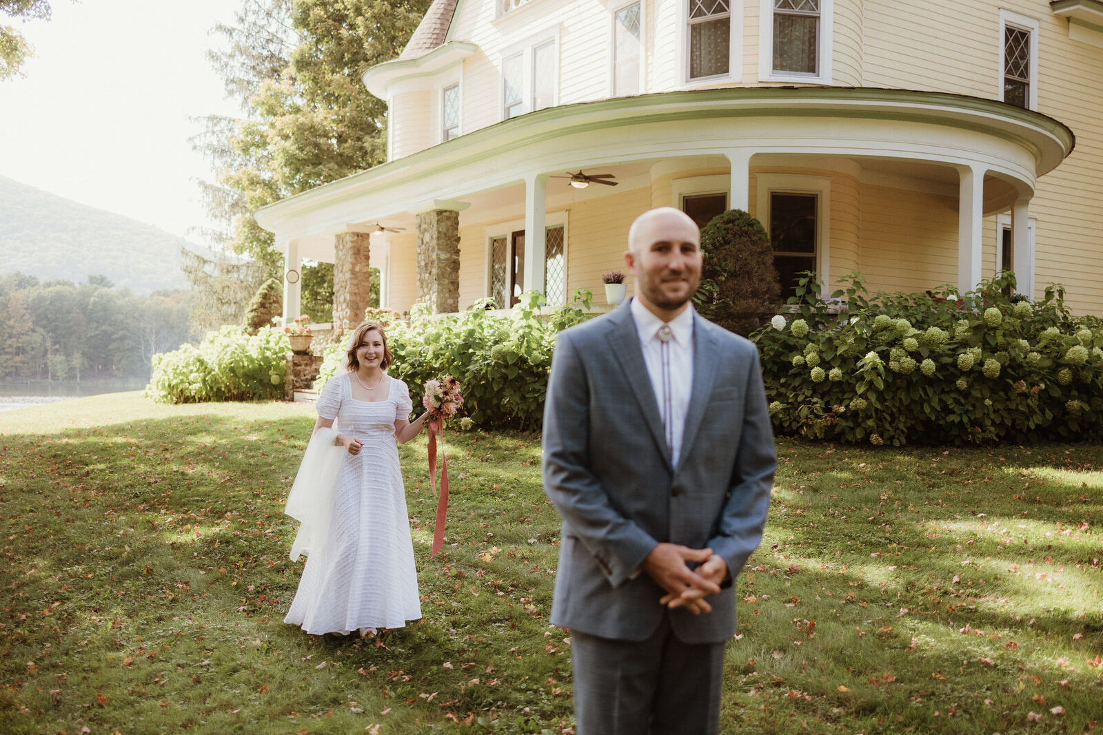 A couple's first look on the lawn in front of the porch