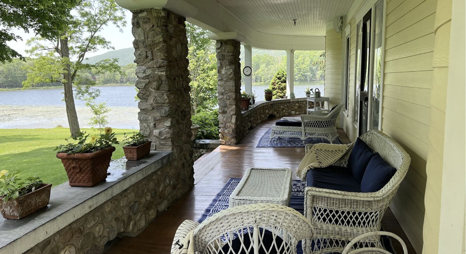 The wraparound porch with wicker furniture looking toward the lake